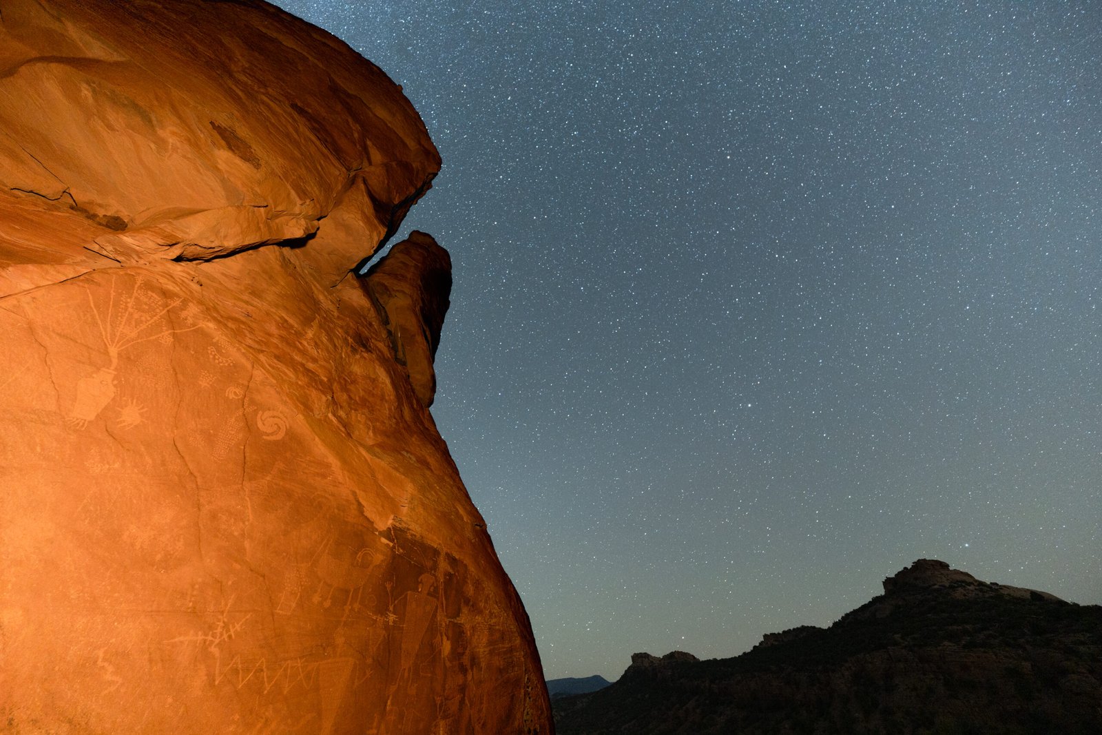 Beautiful Astro Photograph of the night sky with a red cliff full of petraglyphs